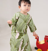 baby girl wearing estate print baby kurung dress and playing toys