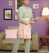 men wearing traditional baju melayu set sage green poses in living room