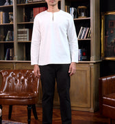 man stands confidently wearing white men teluk belanga top