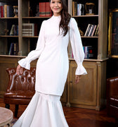 woman dressed in white polka dot jasmine kurung set and posing