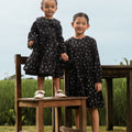 smiling sisters standing posing in holiday dress melati print