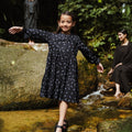 young girl posing in nature wearing holiday dress melati print