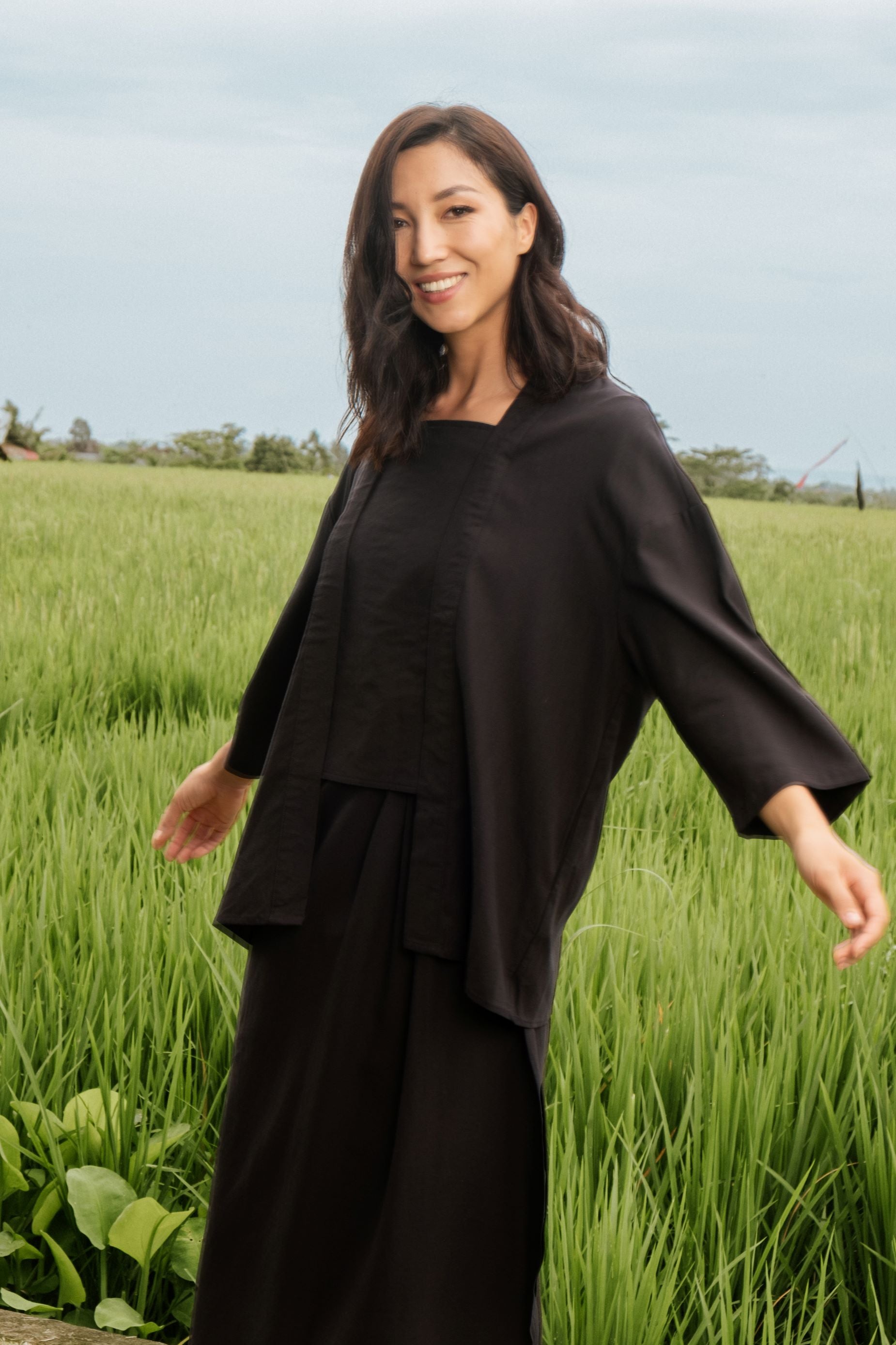 smiling woman posing happily in black 2-in-1 kebaya top