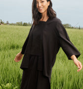 smiling woman posing happily in black 2-in-1 kebaya top