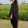 woman posing backwards wearing black 2-in-1 kebaya top