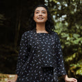 close shot of cheerful woman donning 2-in-1 kebaya top melati print, posing in nature