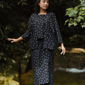 woman looking down posing in melati print 2-in-1 kebaya top