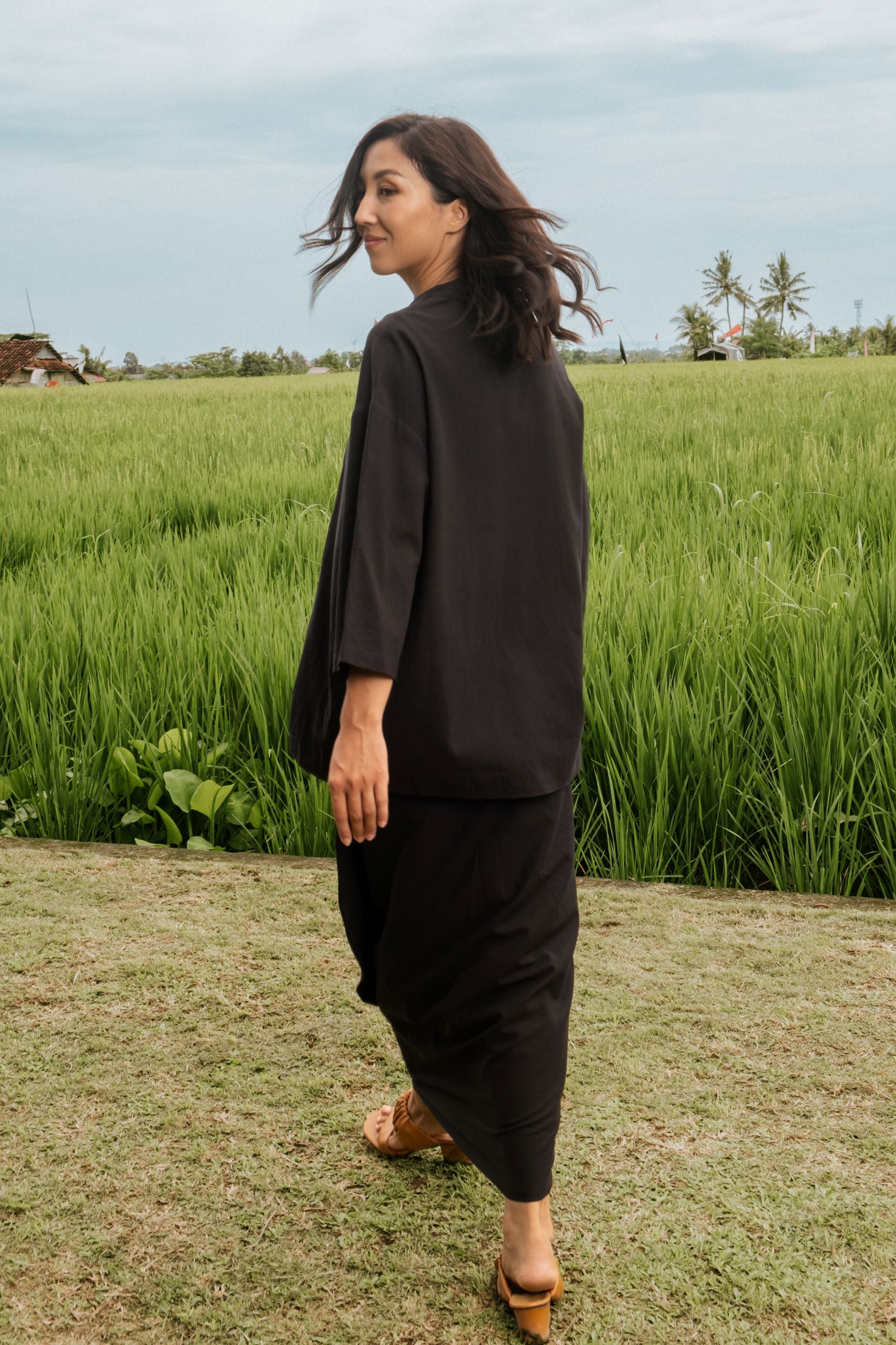 woman looking left, posing backwards wearing instant wrap skirt black