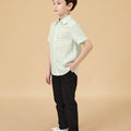 5-6 years old boy wearing short-sleeve button collar shirt pandan print full shot side view