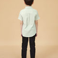 young boy wearing pandan print short-sleeve collar shirt with buttons standing backwards