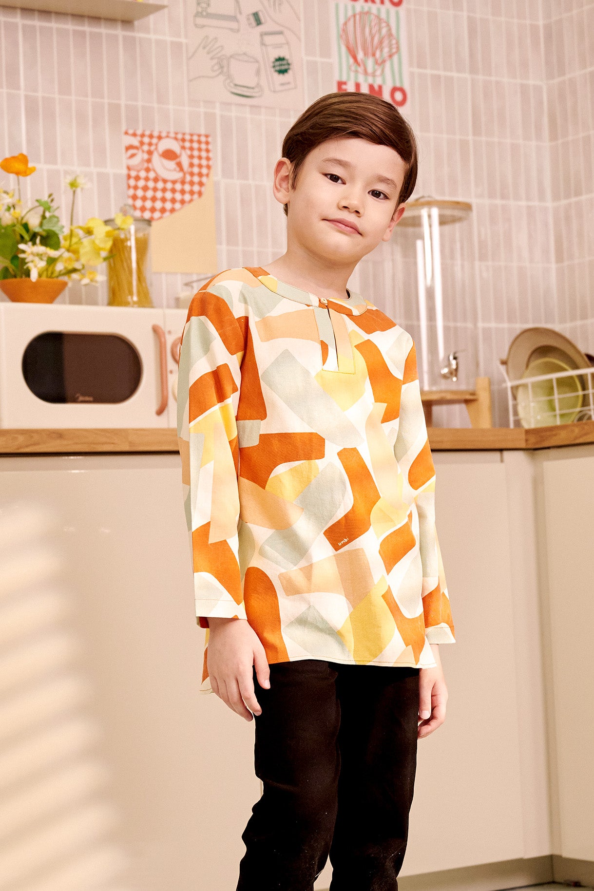 close shot of 5-6 years old boy tilting head wearing marmalade print teluk belanga top