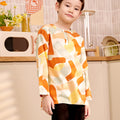 close shot of 5-6 years old boy tilting head wearing marmalade print teluk belanga top