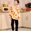 boy staring sideways in marmalade print orange teluk belanga top