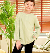 boy posing with one hand in pocket wearing mint green teluk belanga top close shot