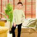 boy standing with one hand in pocket wearing mint green teluk belanga top full body shot