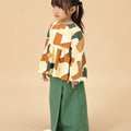 sideways posing of little girl in pine green classic skirt