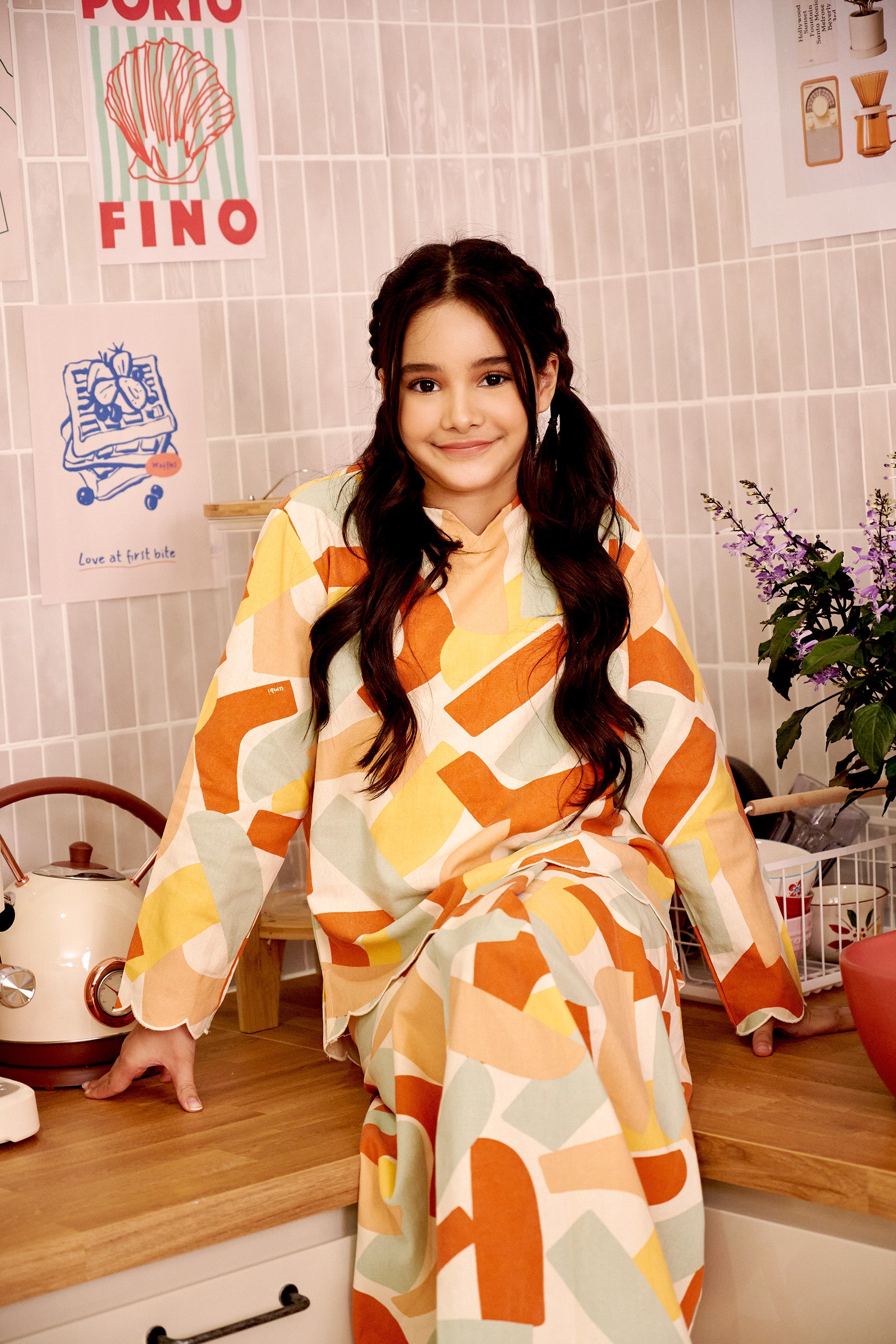 smiling young girl donning marmalade print kurung top with scallop embroidery