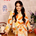 smiling young girl donning marmalade print kurung top with scallop embroidery