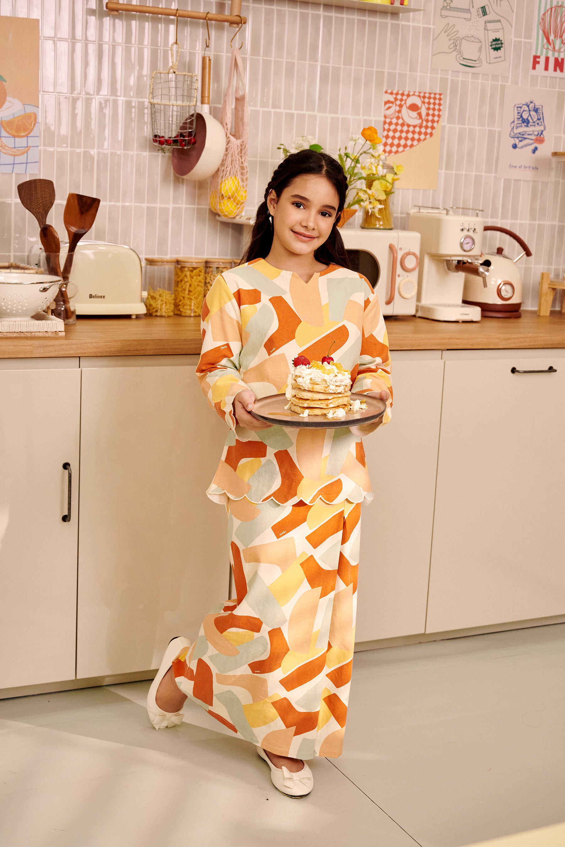 girl holding a plate of pancakes wearing kurung top with scallop embroidery marmalade print 