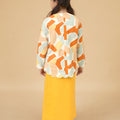 backwards posing of girl wearing marmalade print kurung top with scallop embroidery