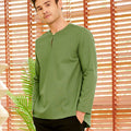 stylish man donning pine green teluk belanga looking at camera 