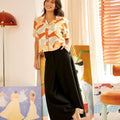 pretty woman in casual blouse marmalade print leaning to the wall