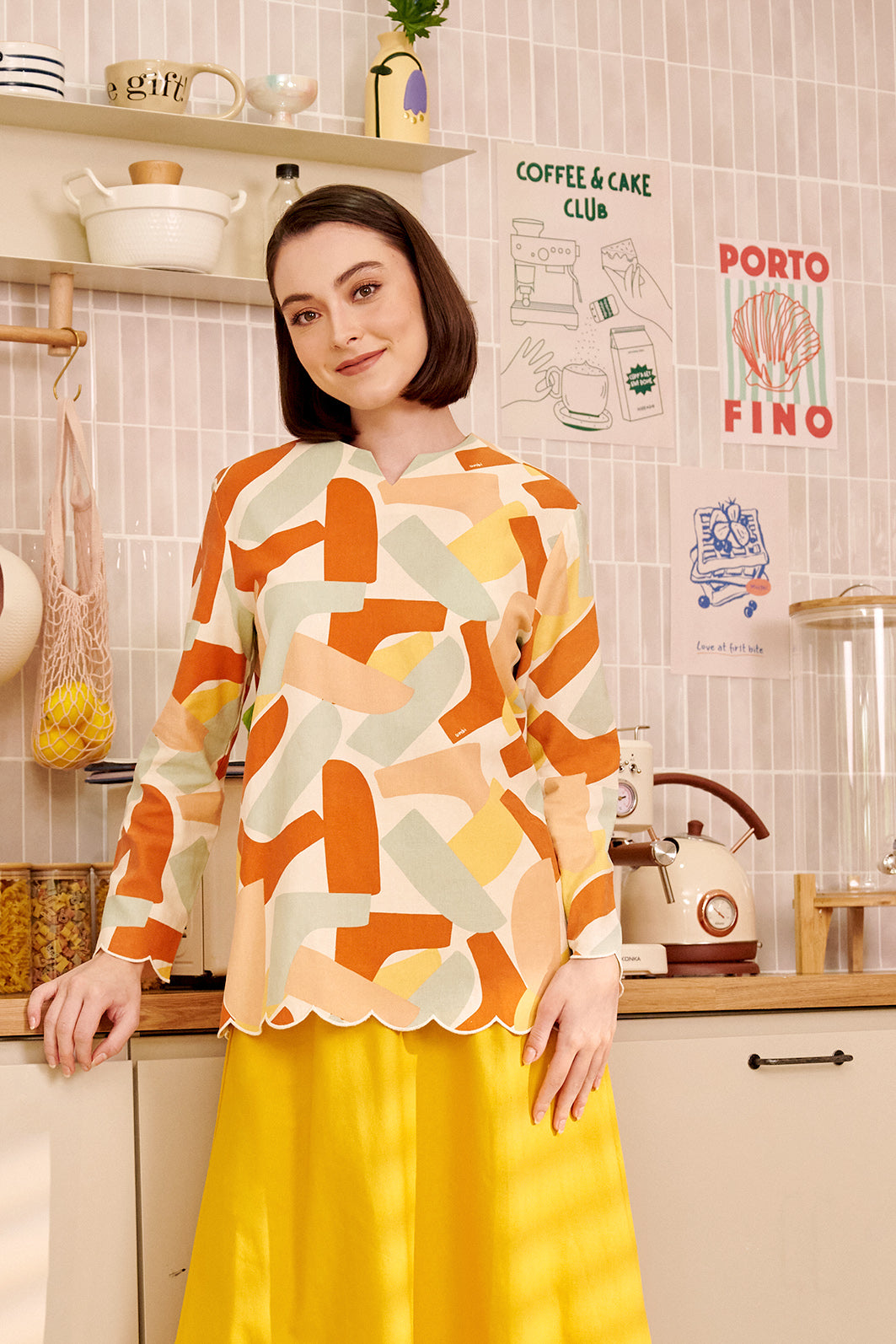 close shot of woman smiling in marmalade print kurung top with scallop embroidery