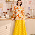 lady in marmalade print kurung top with scallop embroidery leaning against kitchen cabinet