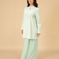 woman standing sideways wearing mandarin collar kurung top pandan print