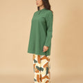 woman in pine green mandarin collar kurung top posing sideways