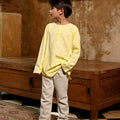 boy looking to the side posing in boy long sleeve kurta butter yellow 