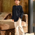 young boy with one hand in pocket donning checked black boy long sleeve kurta