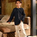 smiling boy posing wearing boy long sleeve kurta checked black