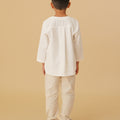 boy standing backwards posing in white teluk belanga top