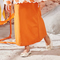 close shot of orange girl column skirt with back pleats