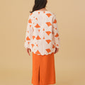 back view of girl wearing column skirt with back pleats orange