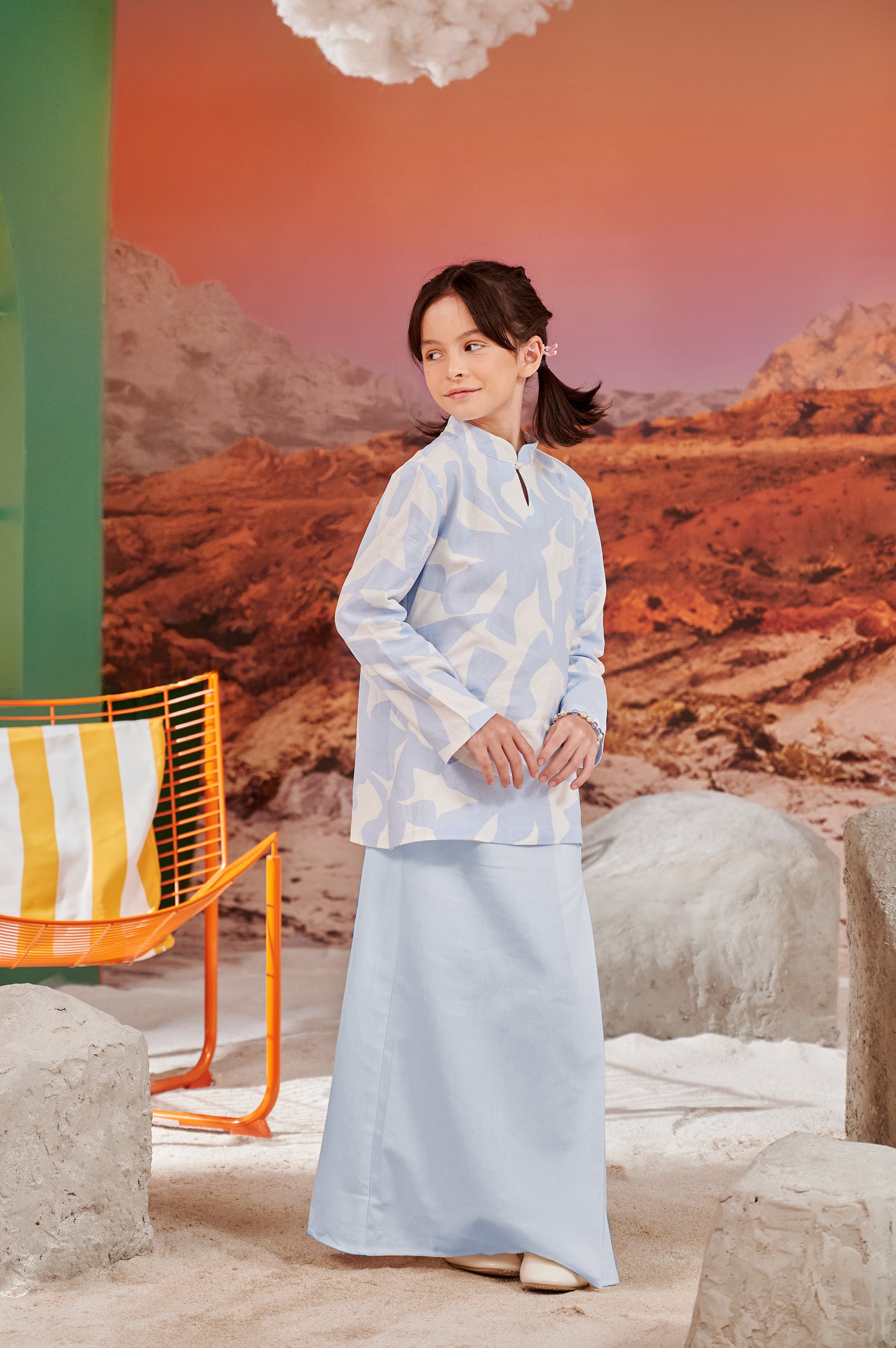 girl gazing right, posing in column skirt with back pleats sky blue