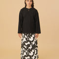 young girl standing pose in black kurung top