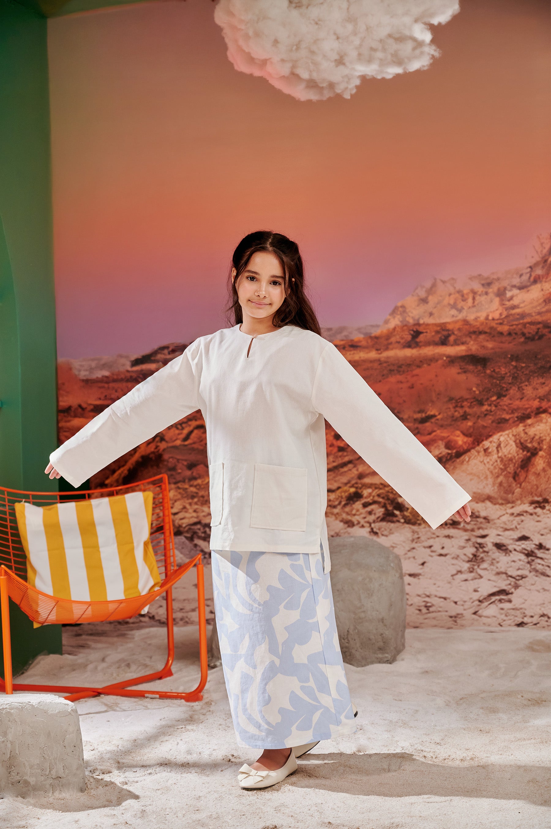 girl posing for the camera wearing kurung top white