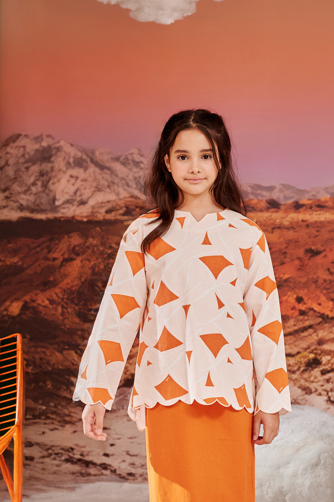 close shot of girl in desert print kurung top with scallop embroidery