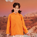 close shot of young girl in orange mandarin collar kurung top