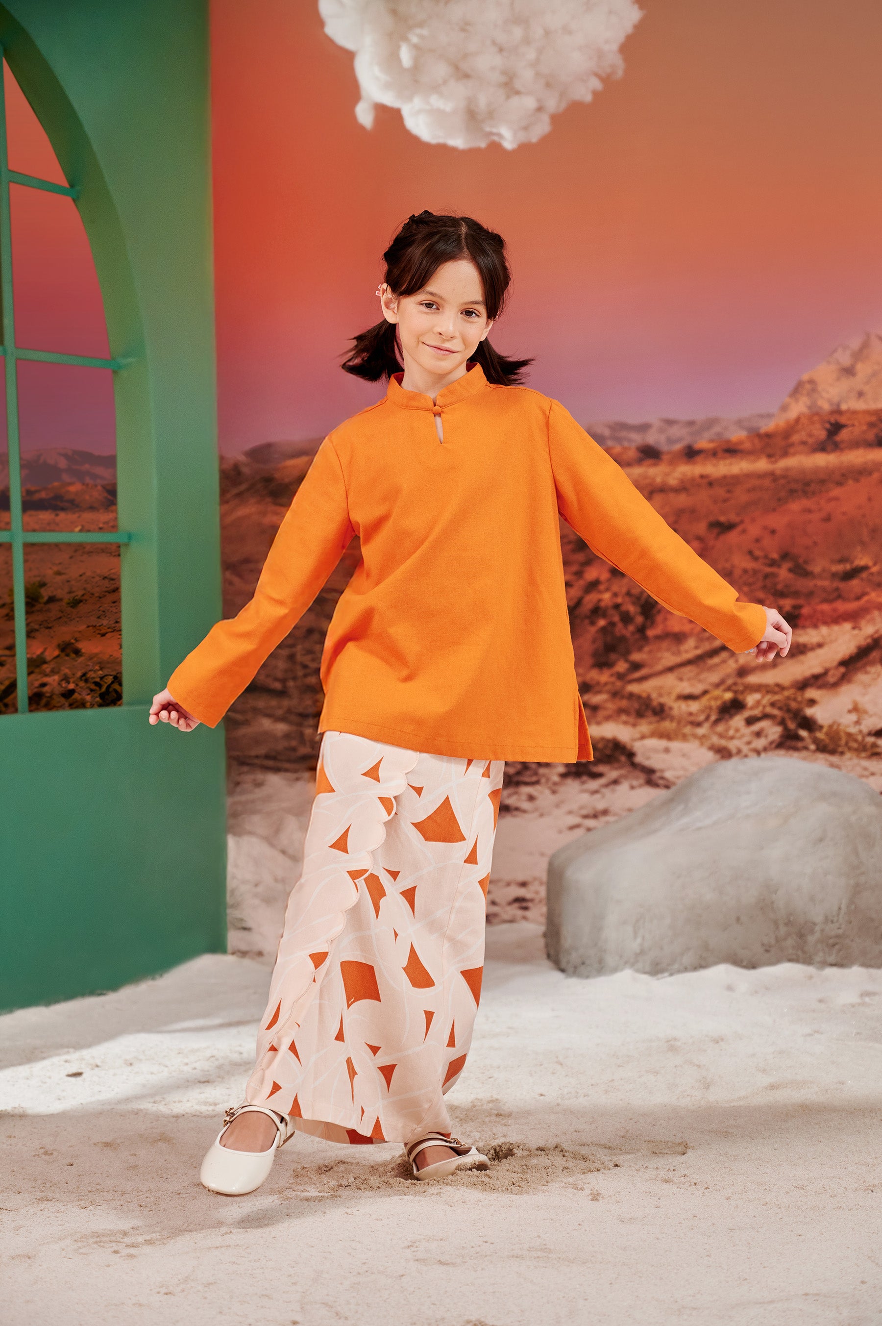 young girl posing in mandarin collar kurung orange