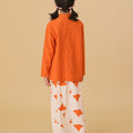 girl standing backwards wearing orange mandarin collar kurung top