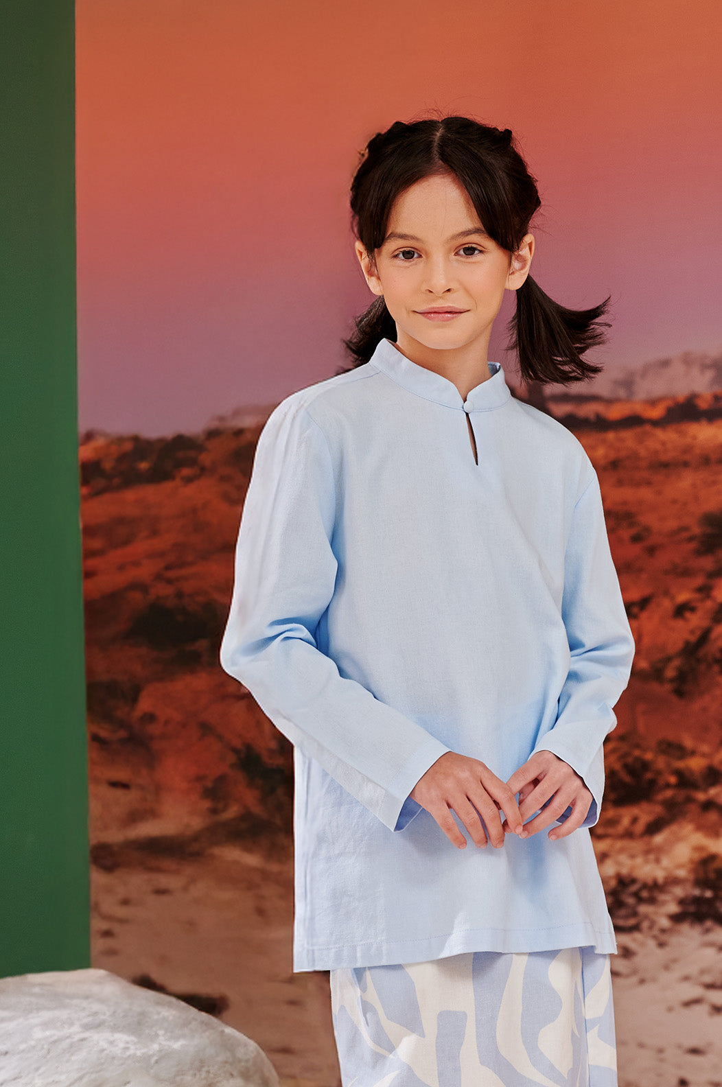 close shot of smiling girl wearing sky blue mandarin collar kurung top