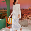 woman looking away and posing in mirage print column skirt with back pleats