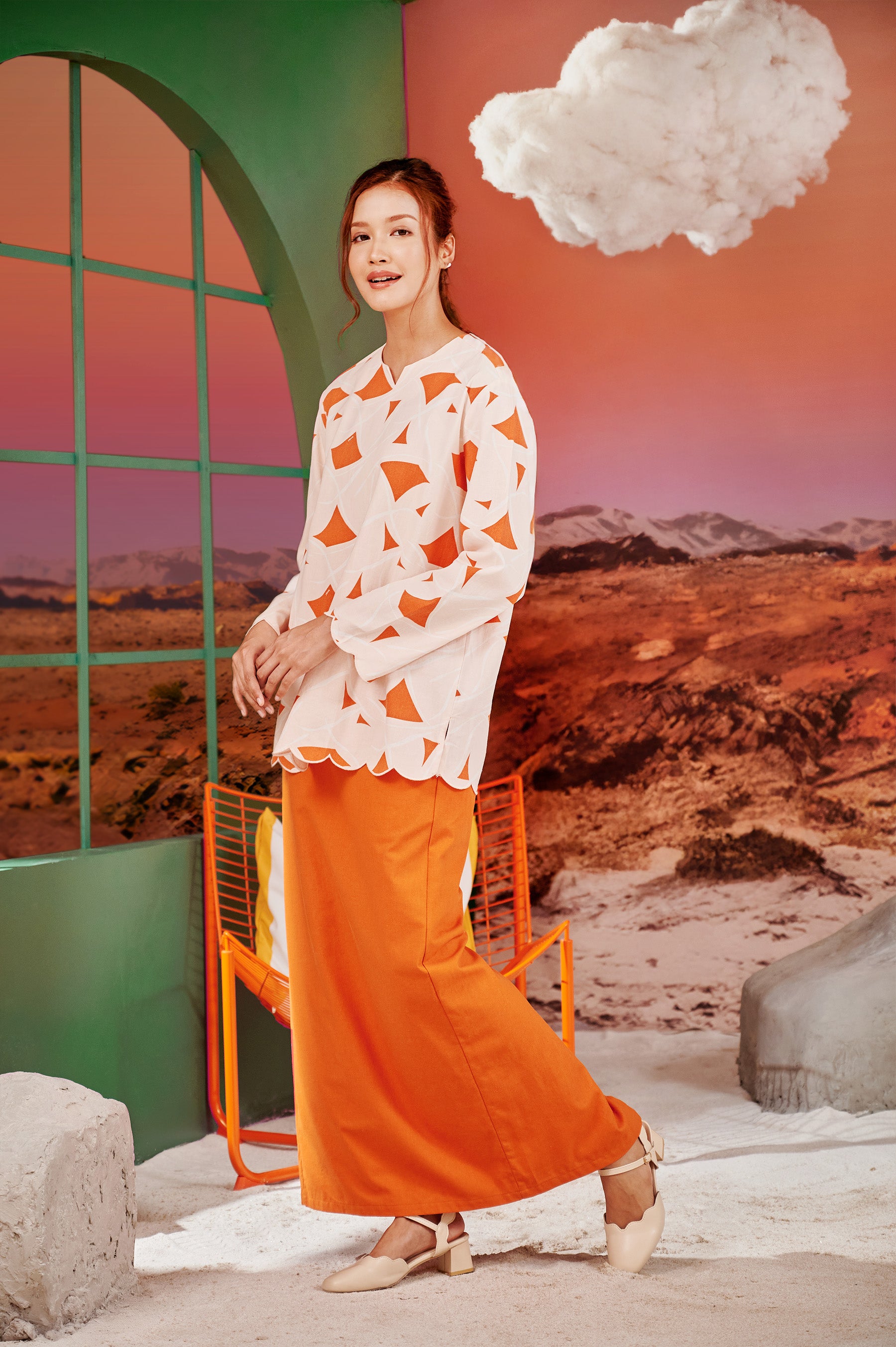 cheerful woman donning column skirt with back pleats orange