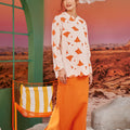 woman looking to the right, posing in column skirt with back pleats orange 