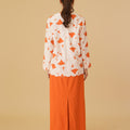 behind view of woman in column skirt with back pleats orange