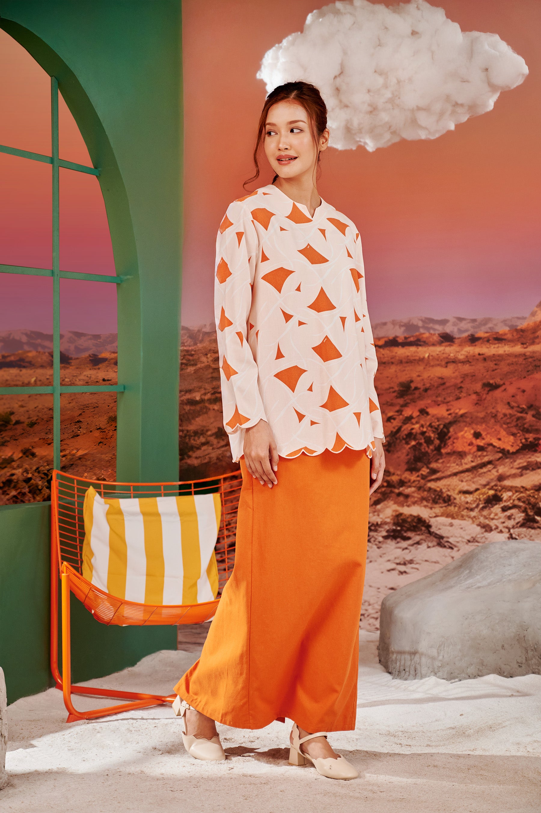 woman staring right posing in kurung top with scallop embroidery desert print