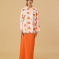 woman standing posing donning desert print kurung top with scallop embroidery